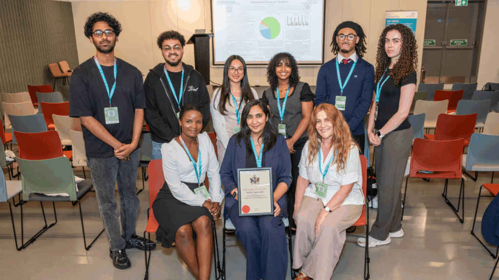 3 males and 6 females, a mix of students and training facilitators, smiling with framed certificate.
